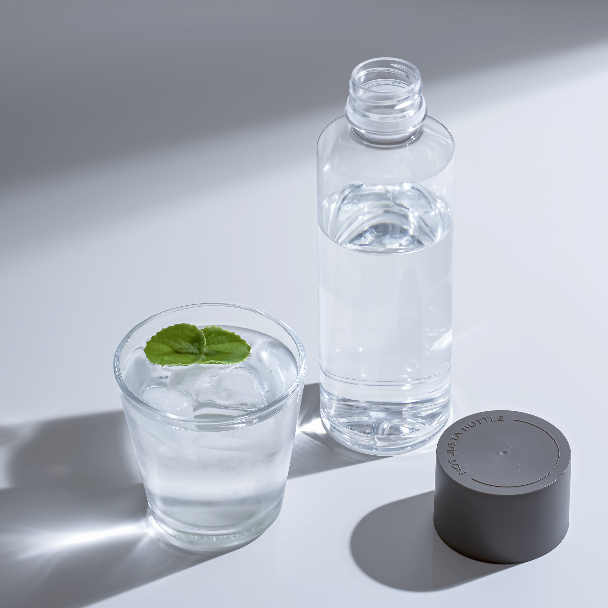 水が入ったボトル、水と葉が入ったコップ