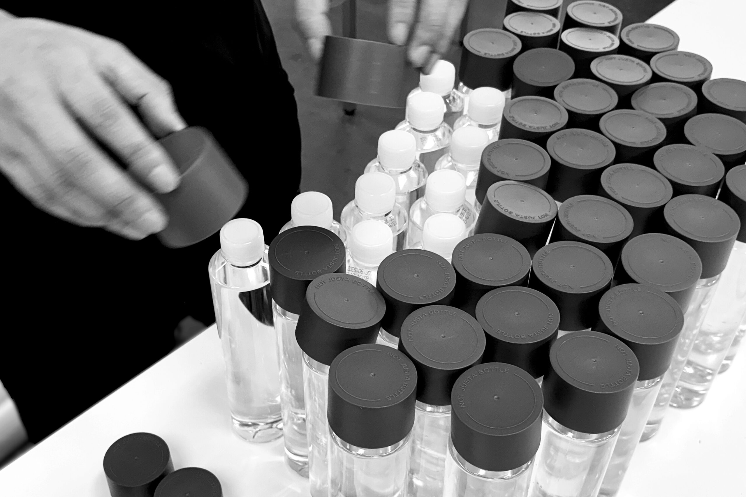 たくさんのボトルにキャップを付ける様子